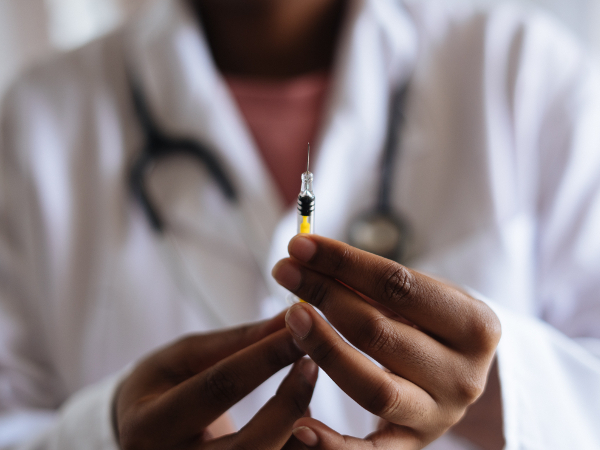 doctor in white coat holding syringe